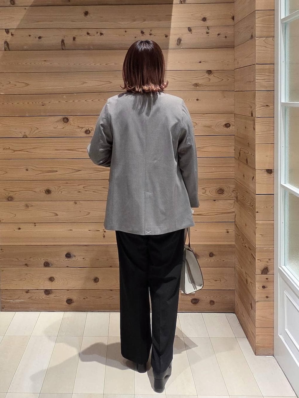 ブラック系のローファー、ホワイト系のショルダーバッグ、ホワイト系のTシャツ/カットソーを着用したレディースの冬コーディネートの3枚目の写真