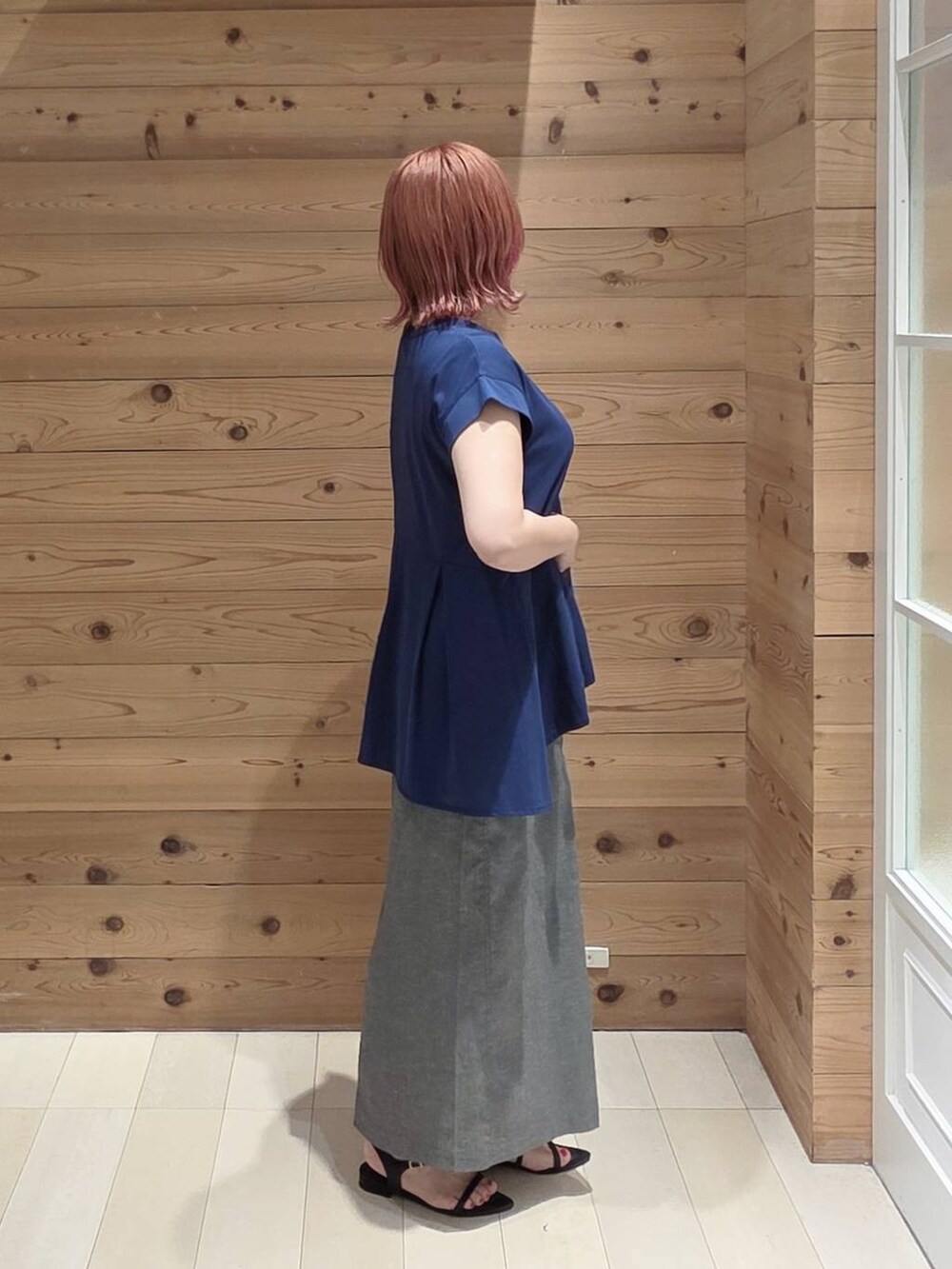グレー系のスカート、ブルー系のTシャツ/カットソー、シルバー系のショルダーバッグを着用したレディースの夏コーディネートの2枚目の写真