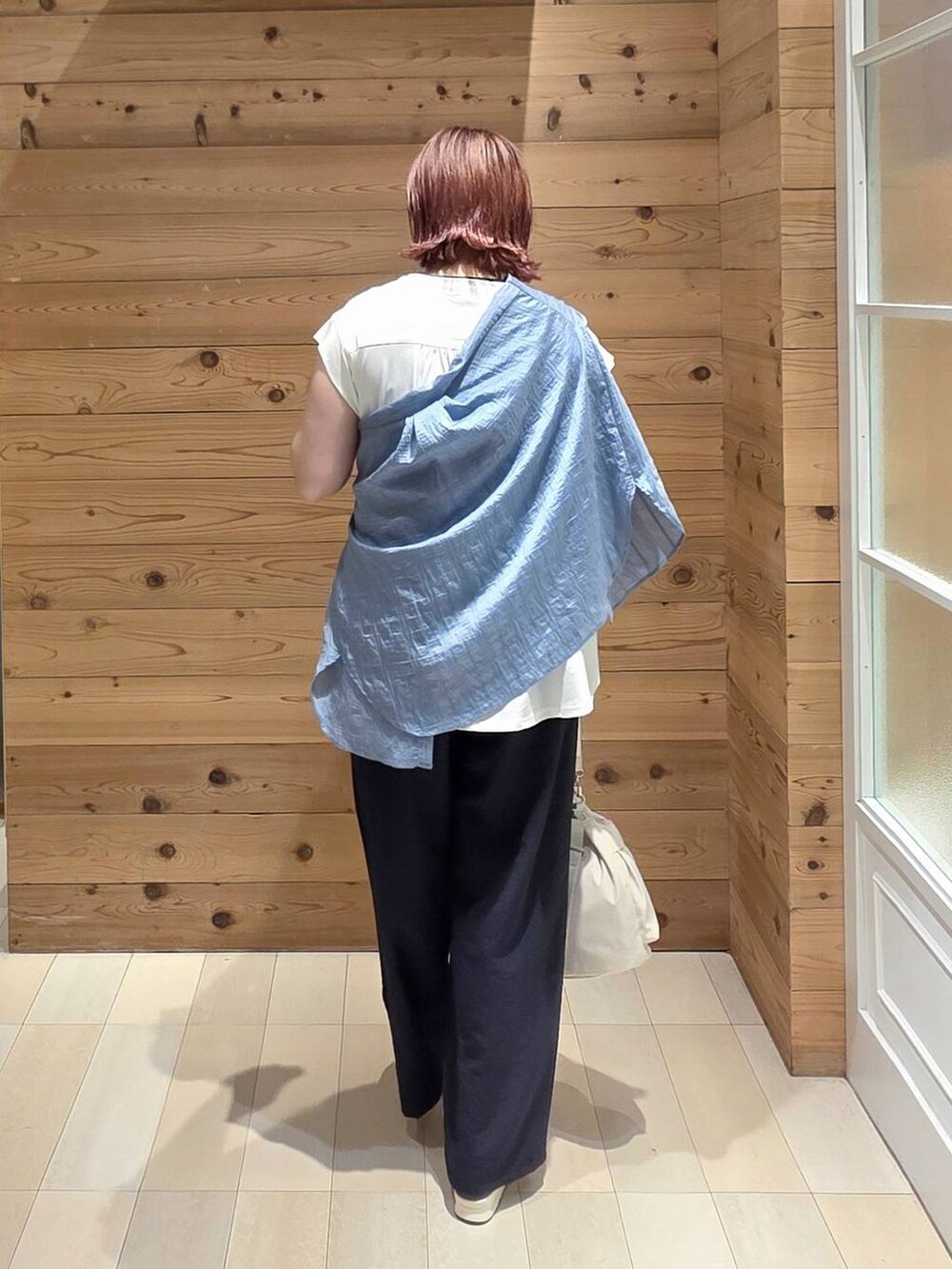 ホワイト系のショルダーバッグ、ブルー系のシャツ/ブラウス、ブラック系のサンダルを着用したレディースの夏コーディネートの3枚目の写真