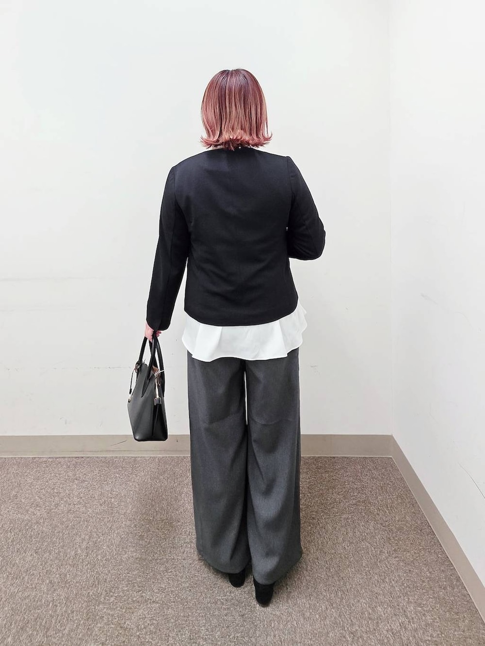 ブラック系のショルダーバッグ、ブラック系のパンプス、ブラック系のセットアップを着用したレディースの冬コーディネートの3枚目の写真