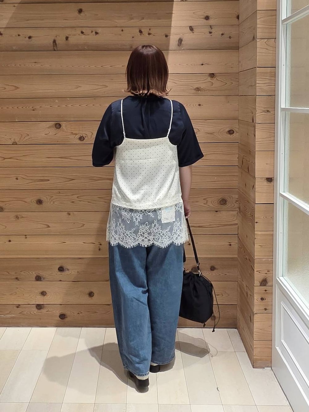 ブルー系のデニムパンツ、ブルー系のシャツ/ブラウス、ホワイト系のキャミソールを着用したレディースの春コーディネートの3枚目の写真