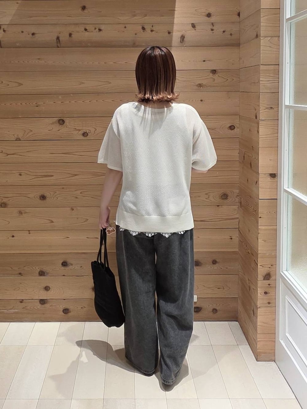 ブラック系のバレエシューズ、ブラック系のデニムパンツ、ブラック系のクラッチバッグを着用したレディースの夏コーディネートの3枚目の写真
