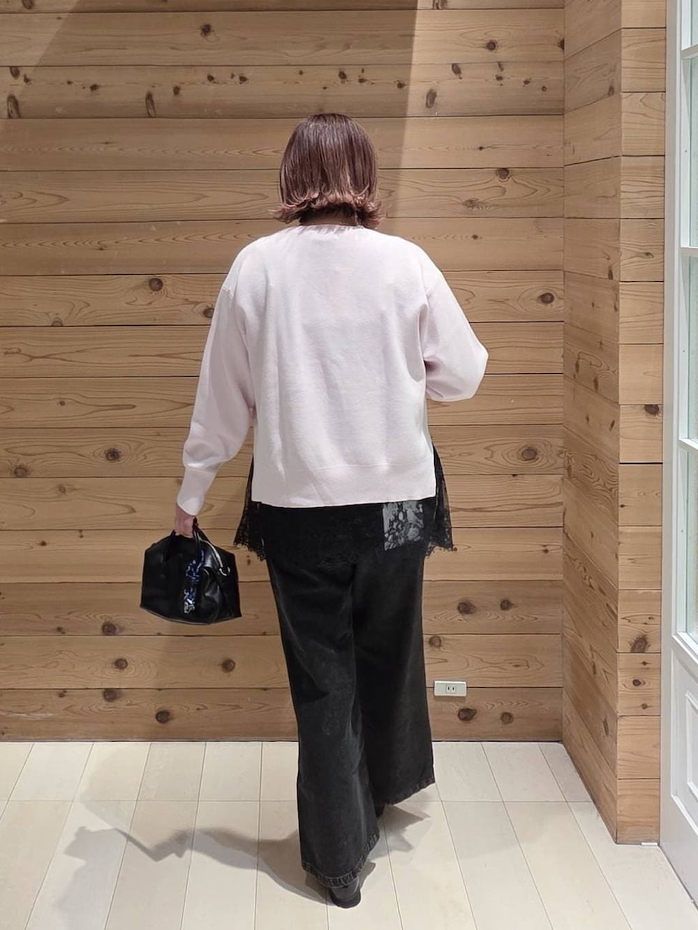 ブラック系のローファー、ブラック系のデニムパンツ、ピンク系のニット/セーターを着用したレディースの春コーディネートの3枚目の写真