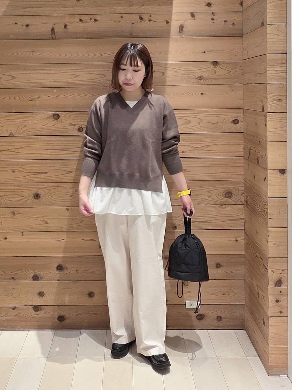 ブラック系のローファー、ブラック系のハンドバッグ、ホワイト系のパーカーを着用したレディースの春コーディネートの4枚目の写真