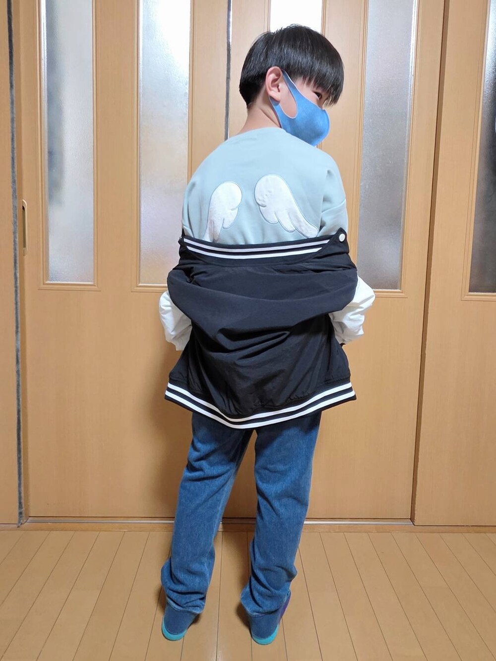 ブルー系のデニムパンツ、ブラック系のブルゾン、グリーン系のスウェットを着用したキッズの秋コーディネートの5枚目の写真