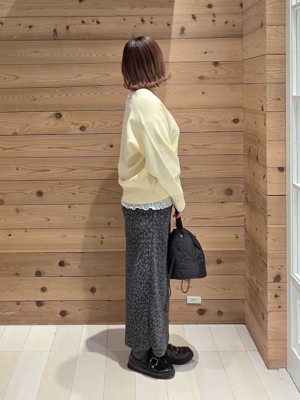 ブラック系のローファー、ブラック系のハンドバッグ、ブラック系のマウンテンパーカーを着用したレディースの春コーディネートの2枚目の写真