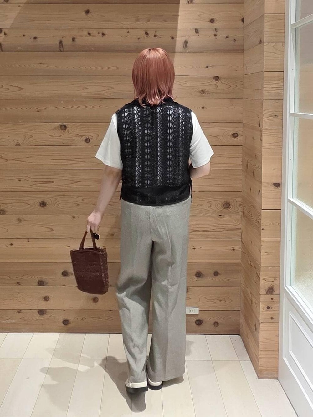 ベージュ系のその他パンツ、ホワイト系のTシャツ/カットソー、ブラウン系のクラッチバッグを着用したレディースの夏コーディネートの3枚目の写真