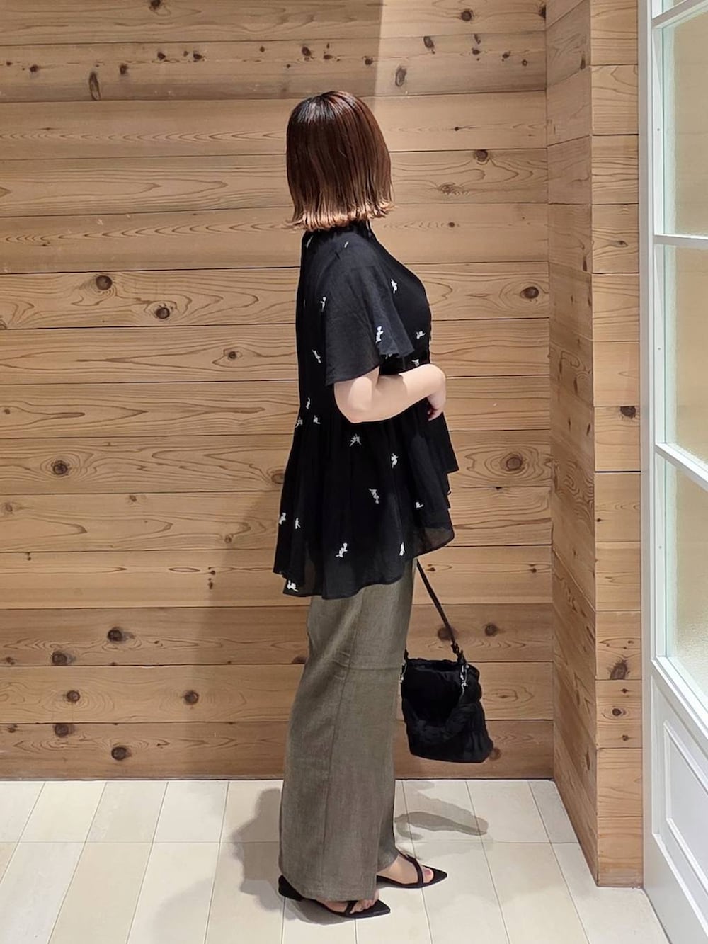 ブラウン系のその他パンツ、ホワイト系のタンクトップ、ブラック系のショルダーバッグを着用したレディースの夏コーディネートの2枚目の写真