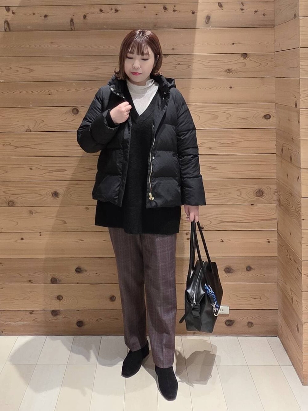 ブラック系のボストンバッグ、ブラック系のダウンジャケット/コート、ブラウン系のその他パンツを着用したレディースの冬コーディネートの4枚目の写真