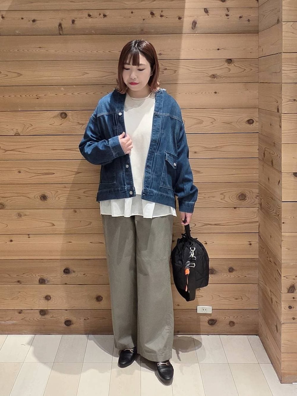 ブラック系のローファー、ブラック系のハンドバッグ、ブルー系のデニムジャケットを着用したレディースの春コーディネートの4枚目の写真