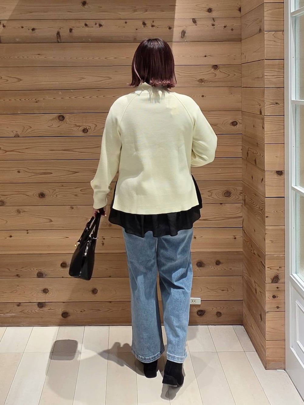 ブラック系のショルダーバッグ、ブルー系のダウンジャケット/コート、ブラック系のTシャツ/カットソーを着用したレディースの冬コーディネートの3枚目の写真