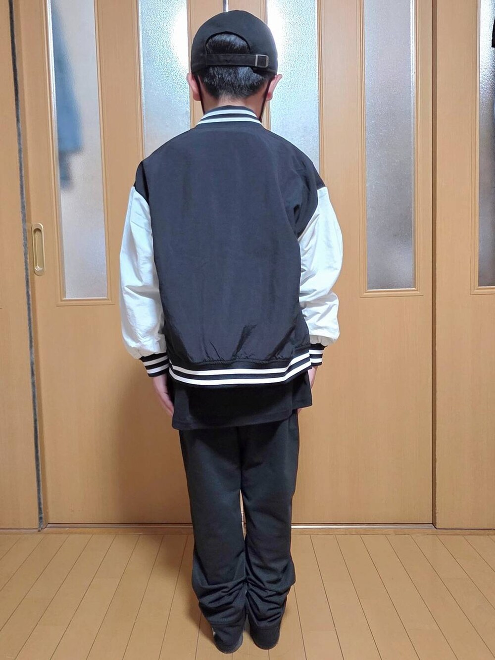 ブラック系のブルゾン、ブラック系のTシャツ/カットソー、ブラック系のキャップを着用したレディースの秋コーディネートの3枚目の写真