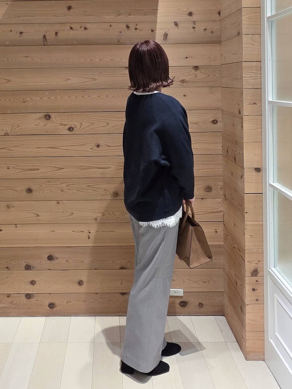 ブラウン系のチェスターコート、グレー系のその他パンツ、ベージュ系のショルダーバッグを着用したレディースの冬コーディネートの2枚目の写真