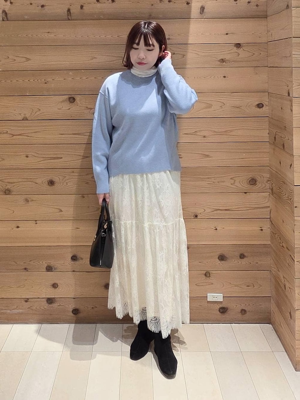 ブラック系のショルダーバッグ、ブルー系のダウンジャケット/コート、ホワイト系のTシャツ/カットソーを着用したレディースの冬コーディネートの4枚目の写真