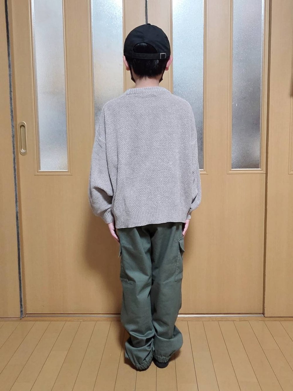 グリーン系のカーゴパンツ、ベージュ系のニット/セーターを着用したキッズの冬コーディネートの3枚目の写真
