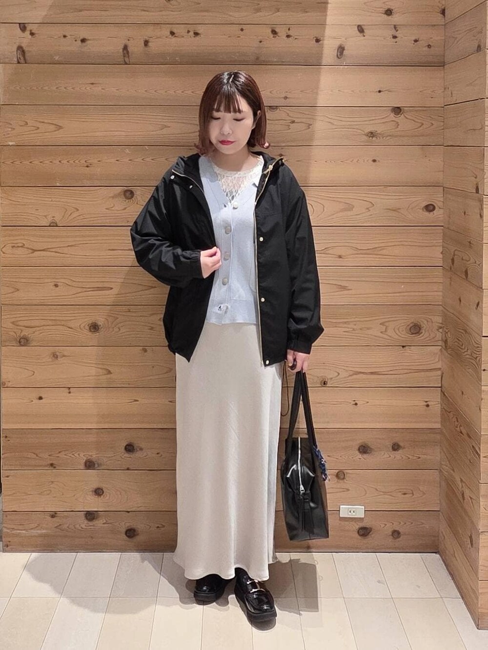 ブラック系のローファー、ブラック系のボストンバッグ、ブラック系のマウンテンパーカーを着用したレディースの春コーディネートの4枚目の写真