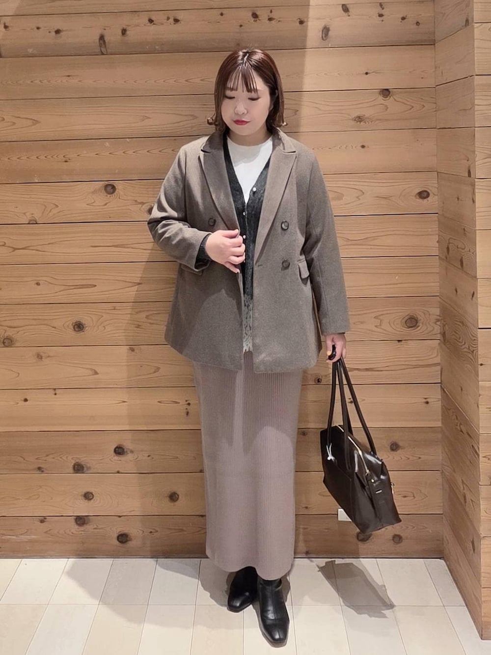 ブラウン系のボストンバッグ、ブラウン系のワンピース、ホワイト系のTシャツ/カットソーを着用したレディースの冬コーディネートの4枚目の写真