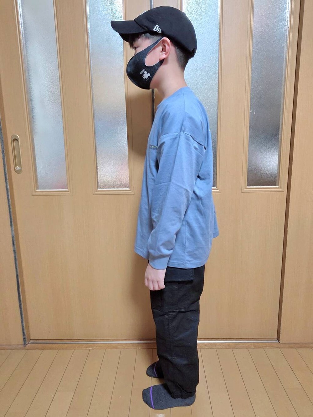 ブラック系のカーゴパンツ、ブルー系のTシャツ/カットソー、ブラック系のキャップを着用したキッズの秋コーディネートの2枚目の写真