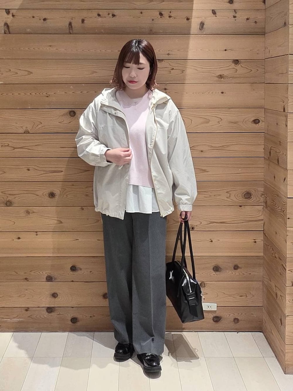 ブラック系のローファー、ブラック系のボストンバッグ、グレー系のスラックスを着用したレディースの春コーディネートの4枚目の写真