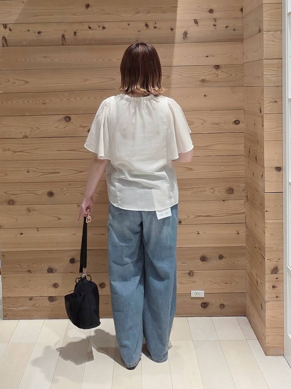 ベージュ系のシャツ/ブラウス、ブルー系のデニムパンツ、ホワイト系のタンクトップを着用したレディースの夏コーディネートの3枚目の写真