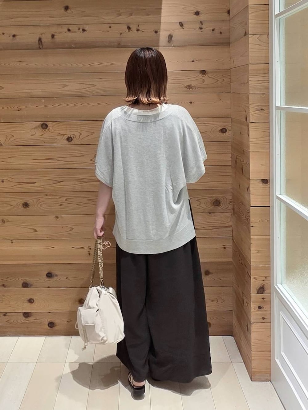 グレー系のカーディガン/ボレロ、ホワイト系のタンクトップ、ブラウン系のその他パンツを着用したレディースの夏コーディネートの3枚目の写真