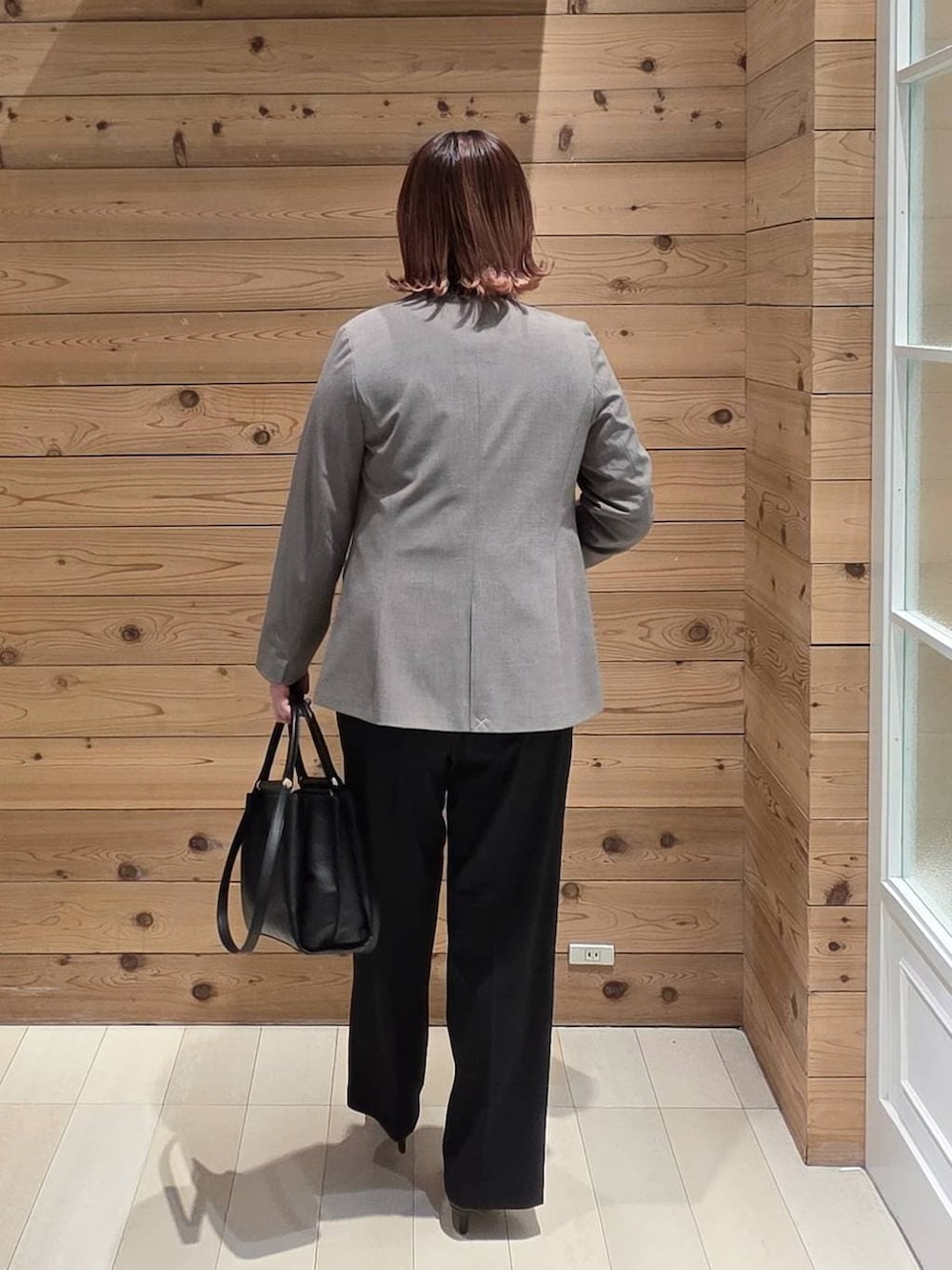 ブラック系のパンプス、ブラック系のスラックス、ホワイト系のシャツ/ブラウスを着用したレディースの冬コーディネートの3枚目の写真