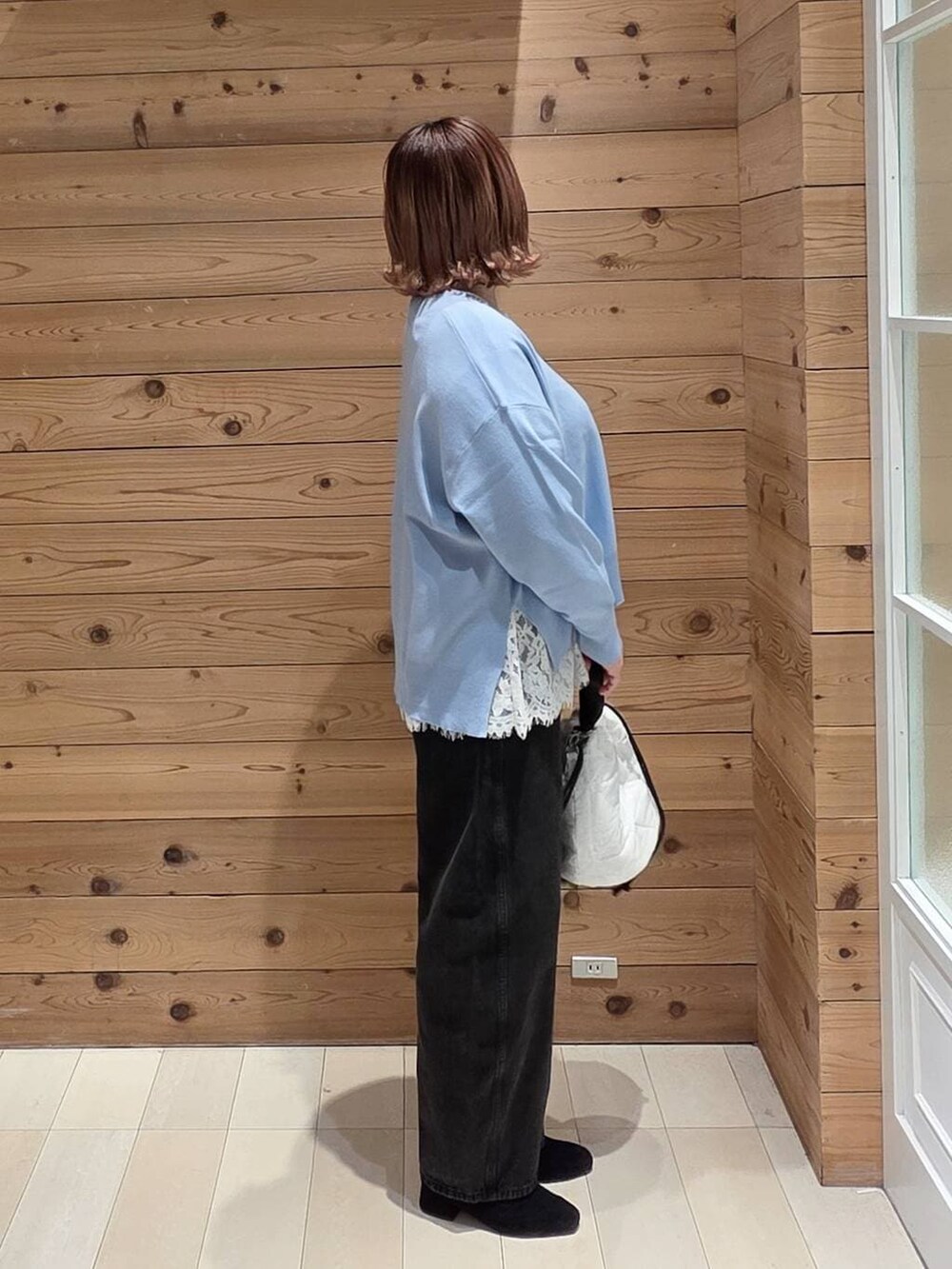 ブルー系のダウンジャケット/コート、ブラック系のデニムパンツ、ホワイト系のハンドバッグを着用したレディースの冬コーディネートの2枚目の写真