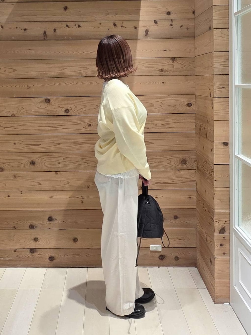 ブラック系のローファー、ブラック系のハンドバッグ、イエロー系のカーディガン/ボレロを着用したレディースの春コーディネートの2枚目の写真