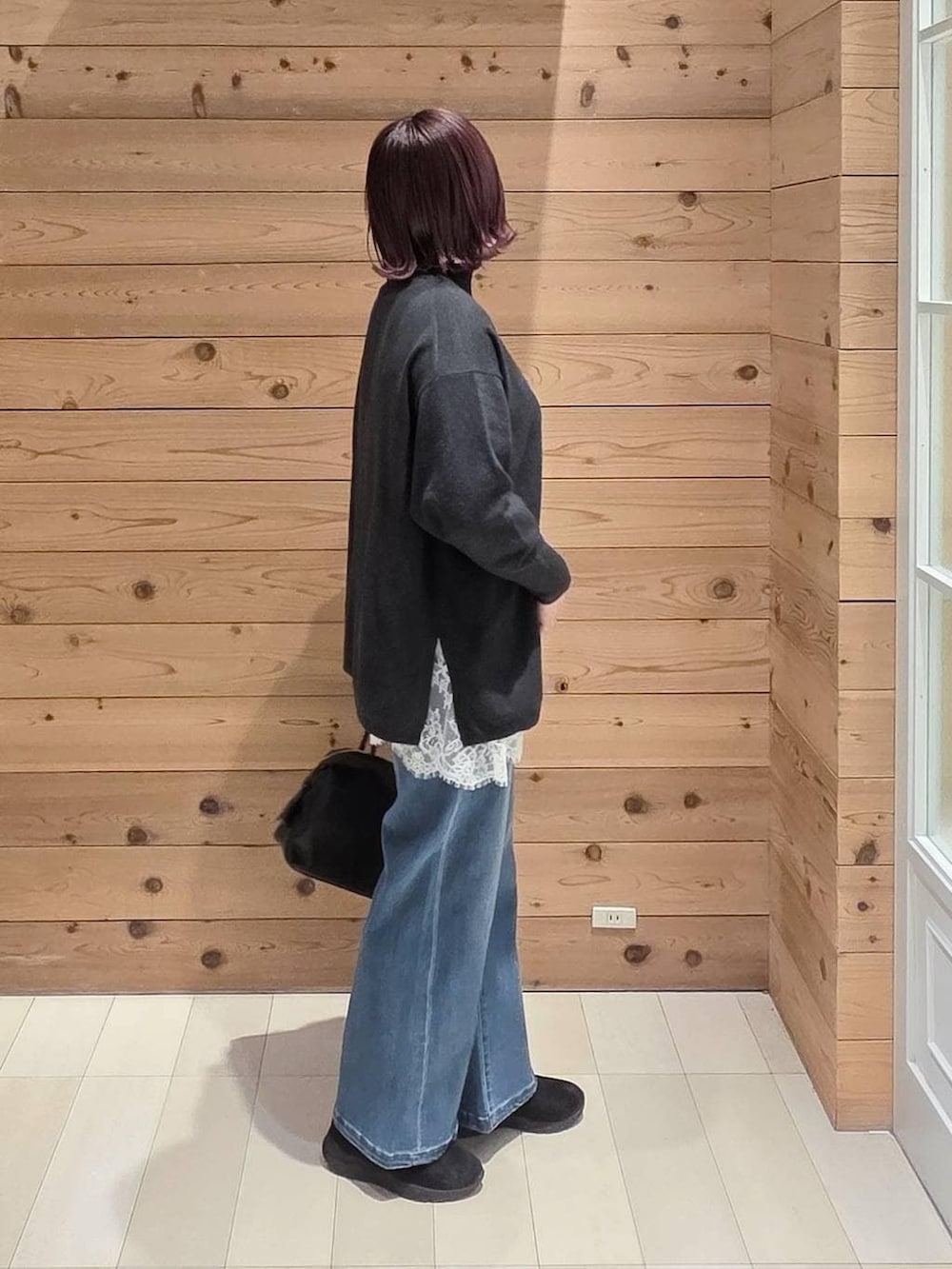 ブラック系のダウンジャケット/コート、ブラック系のボストンバッグ、ブラック系のブーツを着用したレディースの冬コーディネートの2枚目の写真