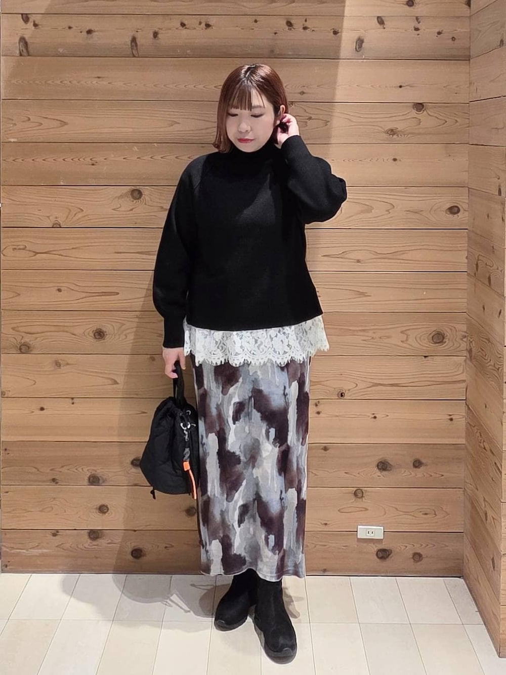 ベージュ系のダウンジャケット/コート、ブラック系のハンドバッグ、ブラック系のブーツを着用したレディースの冬コーディネートの4枚目の写真