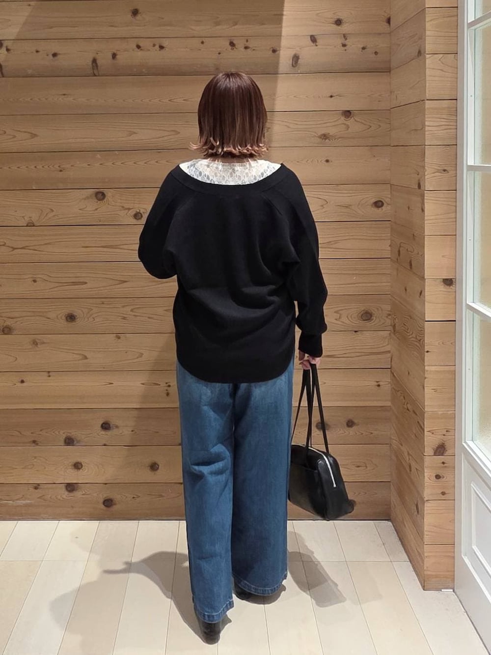 ブラック系のバレエシューズ、ブルー系のデニムパンツ、ブラック系のカーディガン/ボレロを着用したレディースの春コーディネートの3枚目の写真