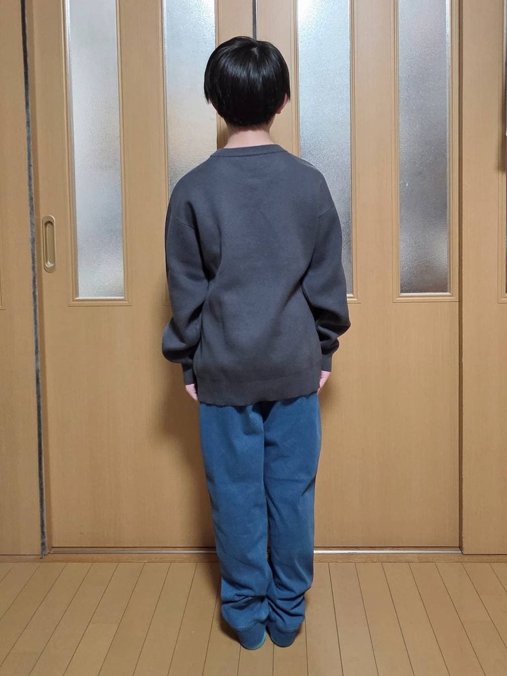 ブルー系のデニムパンツ、グレー系のニット/セーターを着用したキッズの冬コーディネートの3枚目の写真