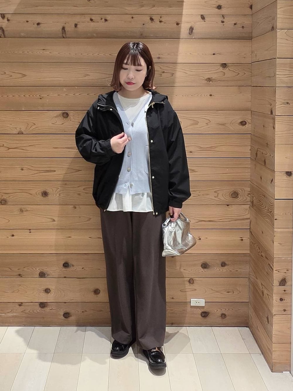 シルバー系のショルダーバッグ、ブラック系のローファー、ブラック系のマウンテンパーカーを着用したレディースの春コーディネートの4枚目の写真