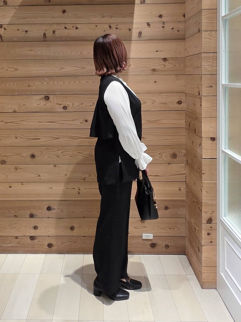 ブラック系のローファー、ブラック系のショルダーバッグ、ブラック系のセットアップを着用したレディースの冬コーディネートの2枚目の写真