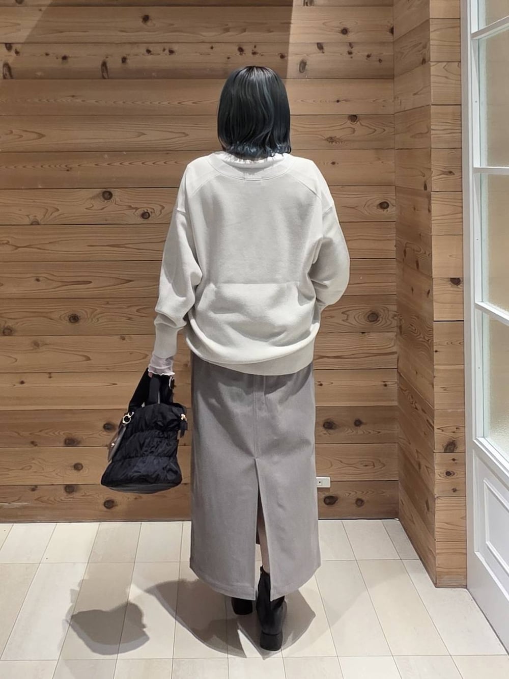 ホワイト系のTシャツ/カットソー、ブラック系のトートバッグ、グリーン系のカーディガン/ボレロを着用したレディースの秋コーディネートの3枚目の写真