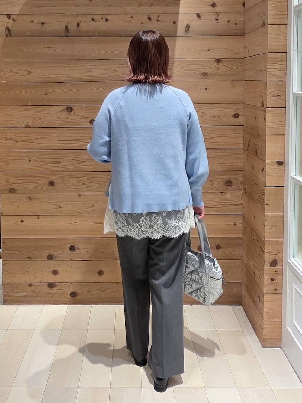 ブラック系のローファー、シルバー系のトートバッグ、グレー系のスラックスを着用したレディースの冬コーディネートの3枚目の写真