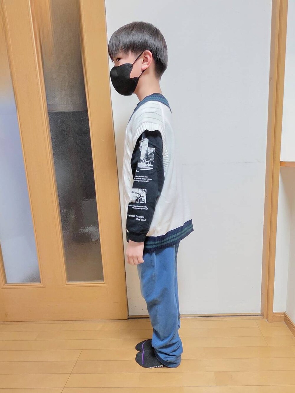 ブルー系のデニムパンツ、ベージュ系のベストを着用したキッズの春コーディネートの2枚目の写真