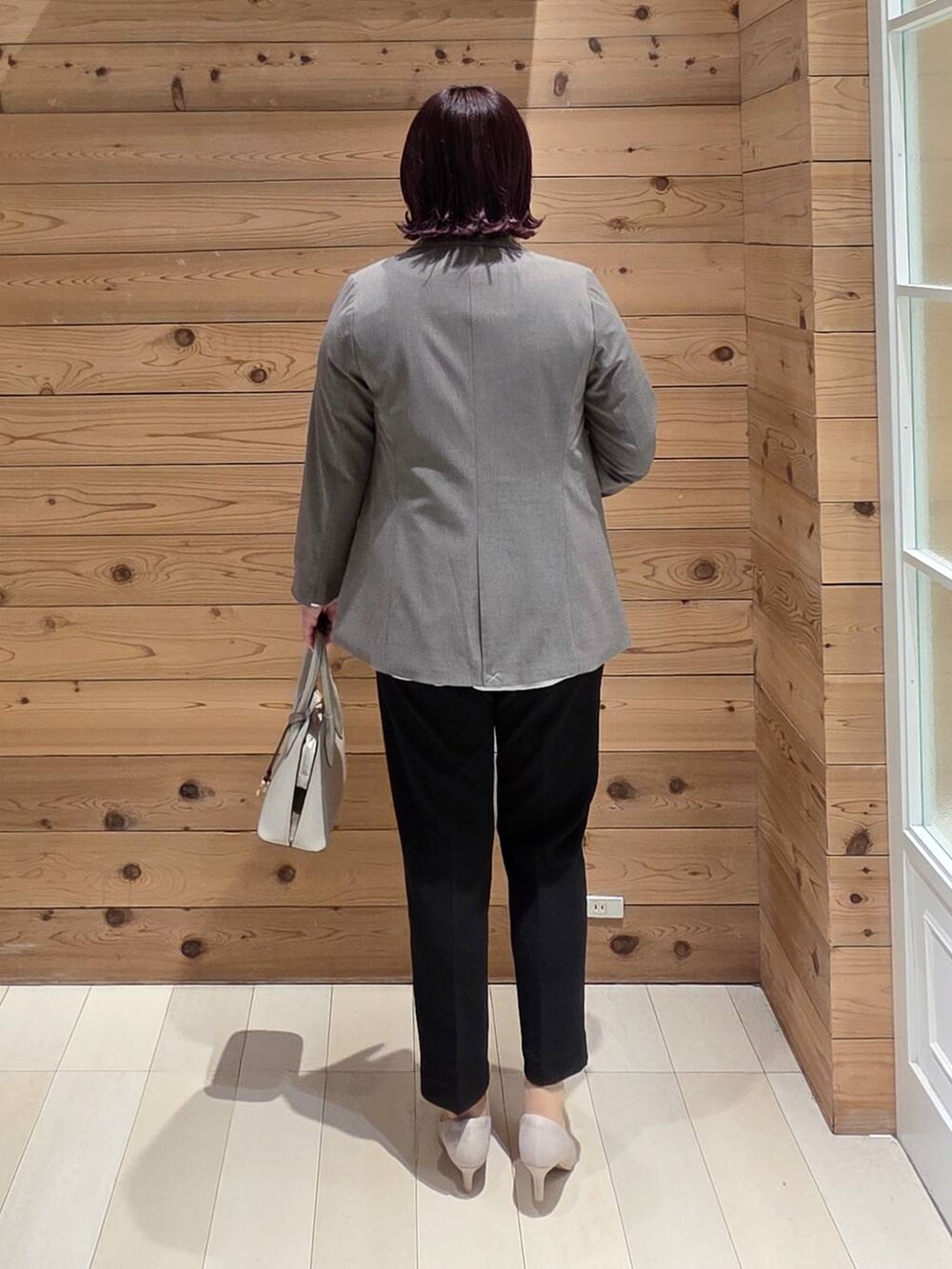 ホワイト系のショルダーバッグ、ホワイト系のパンプス、ブラック系のセットアップを着用したレディースの春コーディネートの3枚目の写真