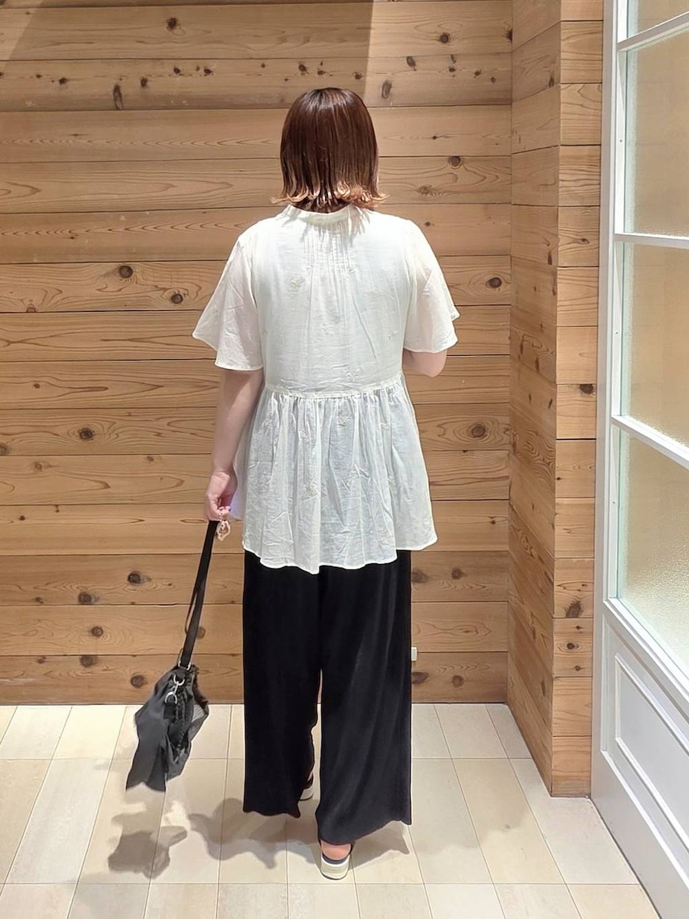 ホワイト系のタンクトップ、ブラック系のその他パンツ、グレー系のショルダーバッグを着用したレディースの夏コーディネートの3枚目の写真