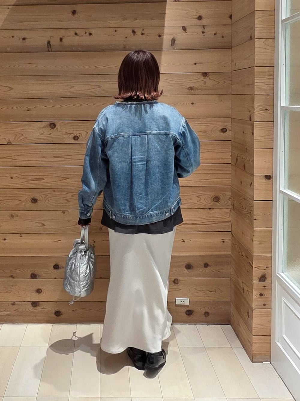 ブラック系のローファー、シルバー系のハンドバッグ、グレー系のスカートを着用したレディースの春コーディネートの3枚目の写真