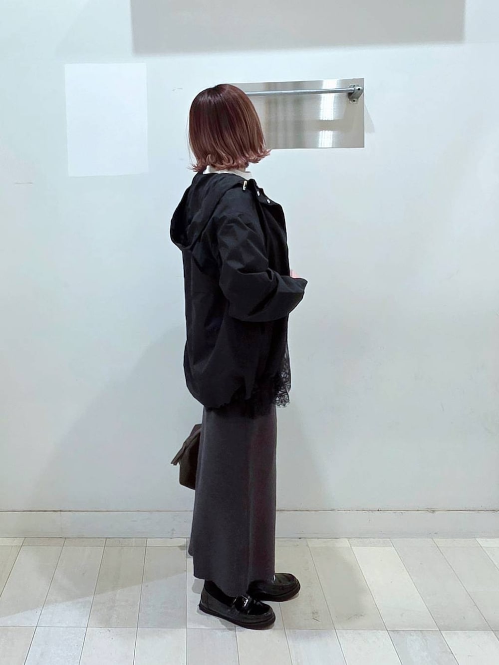 ブラック系のローファー、ブラウン系のボストンバッグ、ブラック系のマウンテンパーカーを着用したレディースの春コーディネートの2枚目の写真