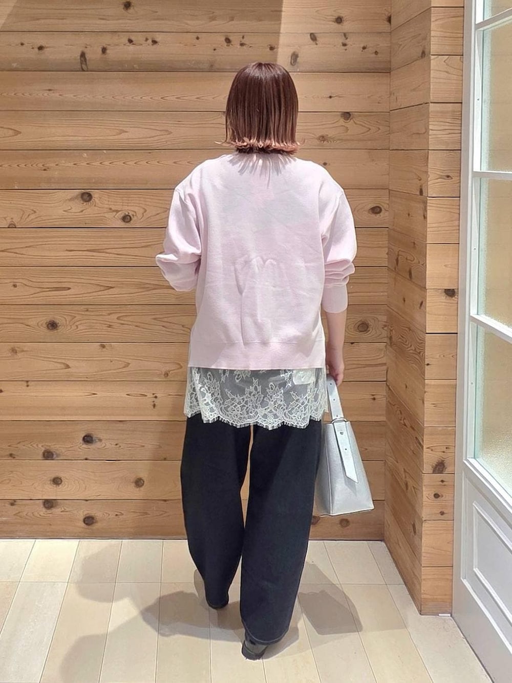 ブラック系のローファー、シルバー系のショルダーバッグ、ブルー系のデニムパンツを着用したレディースの春コーディネートの3枚目の写真