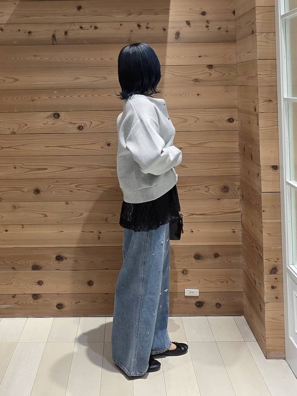 ブルー系のデニムパンツ、グレー系のカーディガン/ボレロ、ブラック系のバレエシューズを着用したレディースの秋コーディネートの2枚目の写真