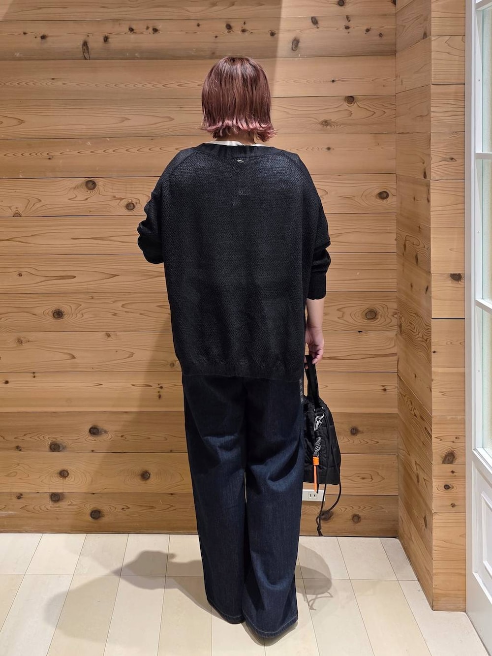 ブラック系のローファー、ブルー系のデニムパンツ、ブラック系のハンドバッグを着用したレディースの秋コーディネートの3枚目の写真