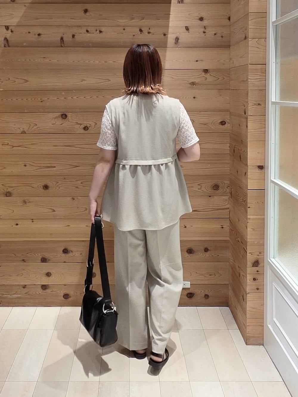 ベージュ系のベスト、ベージュ系のその他パンツ、ブラック系のタンクトップを着用したレディースの夏コーディネートの3枚目の写真