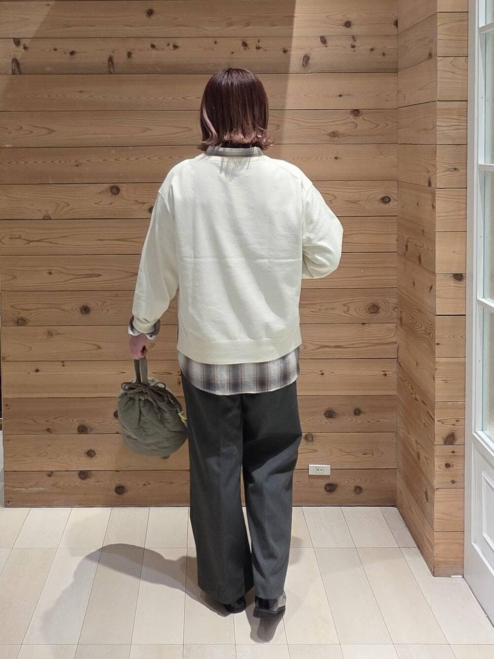 ブラック系のローファー、グリーン系のハンドバッグ、グレー系のその他パンツを着用したレディースの春コーディネートの3枚目の写真