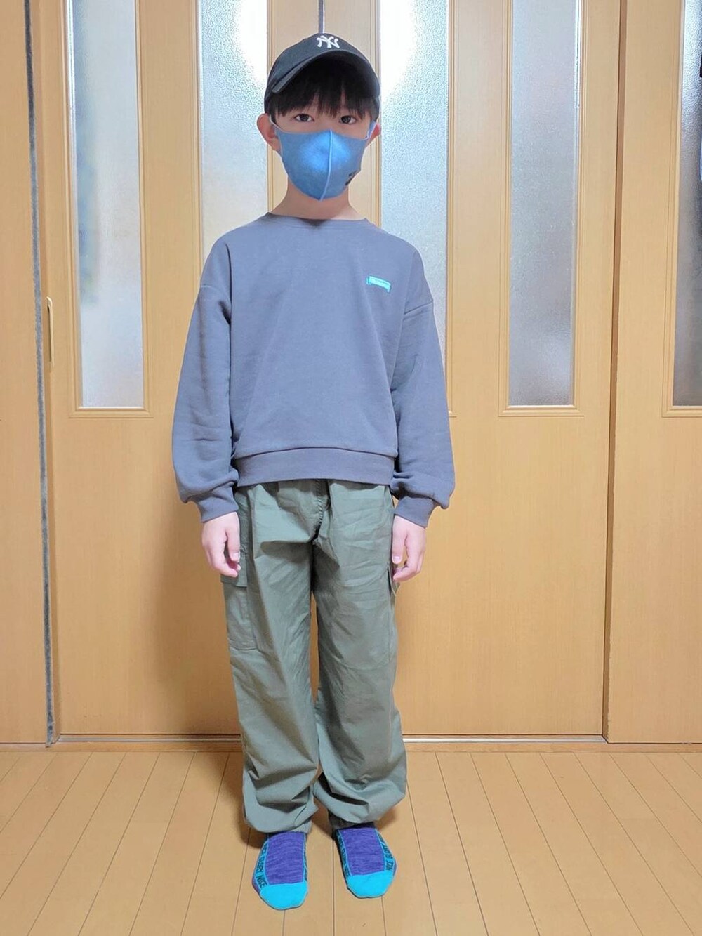 グリーン系のカーゴパンツ、グレー系のスウェット、その他のシュシュを着用したキッズの秋コーディネートの2枚目の写真