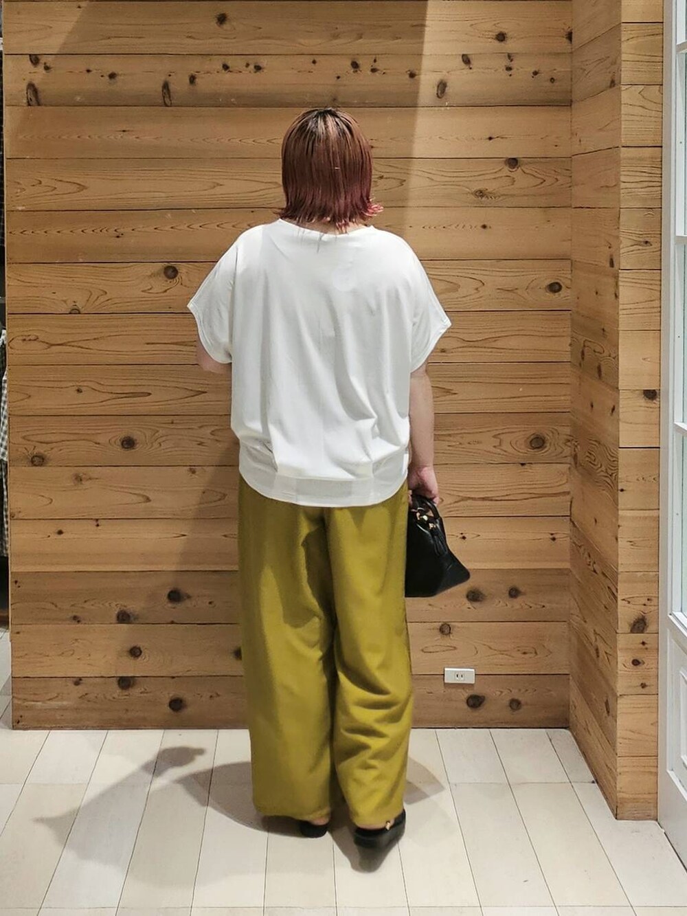 ブラック系のショルダーバッグ、ホワイト系のTシャツ/カットソー、イエロー系のその他パンツを着用したレディースの夏コーディネートの3枚目の写真