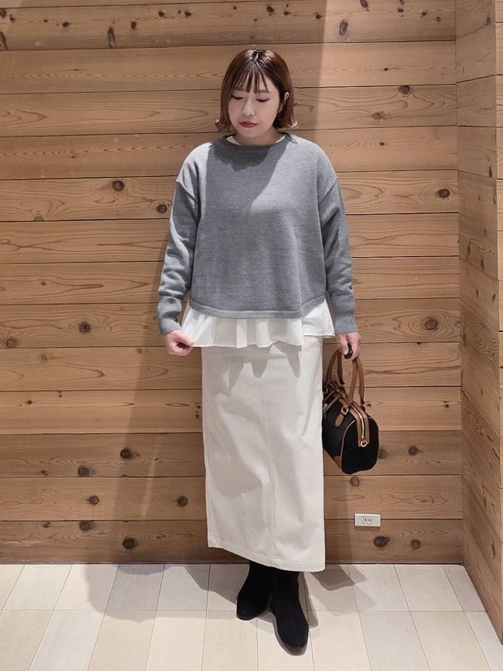 グレー系のニット/セーター、ベージュ系のブルゾン、グレー系のスカートを着用したレディースの冬コーディネートの4枚目の写真