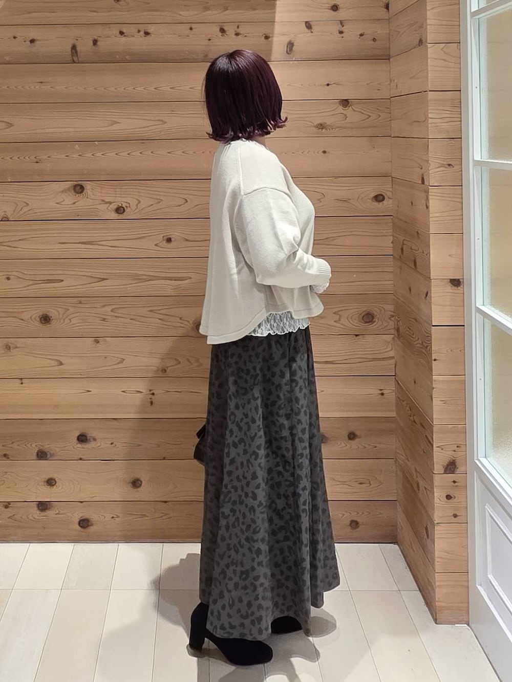 ホワイト系のマウンテンパーカー、ベージュ系のニット/セーター、ブラック系のボストンバッグを着用したレディースの冬コーディネートの2枚目の写真